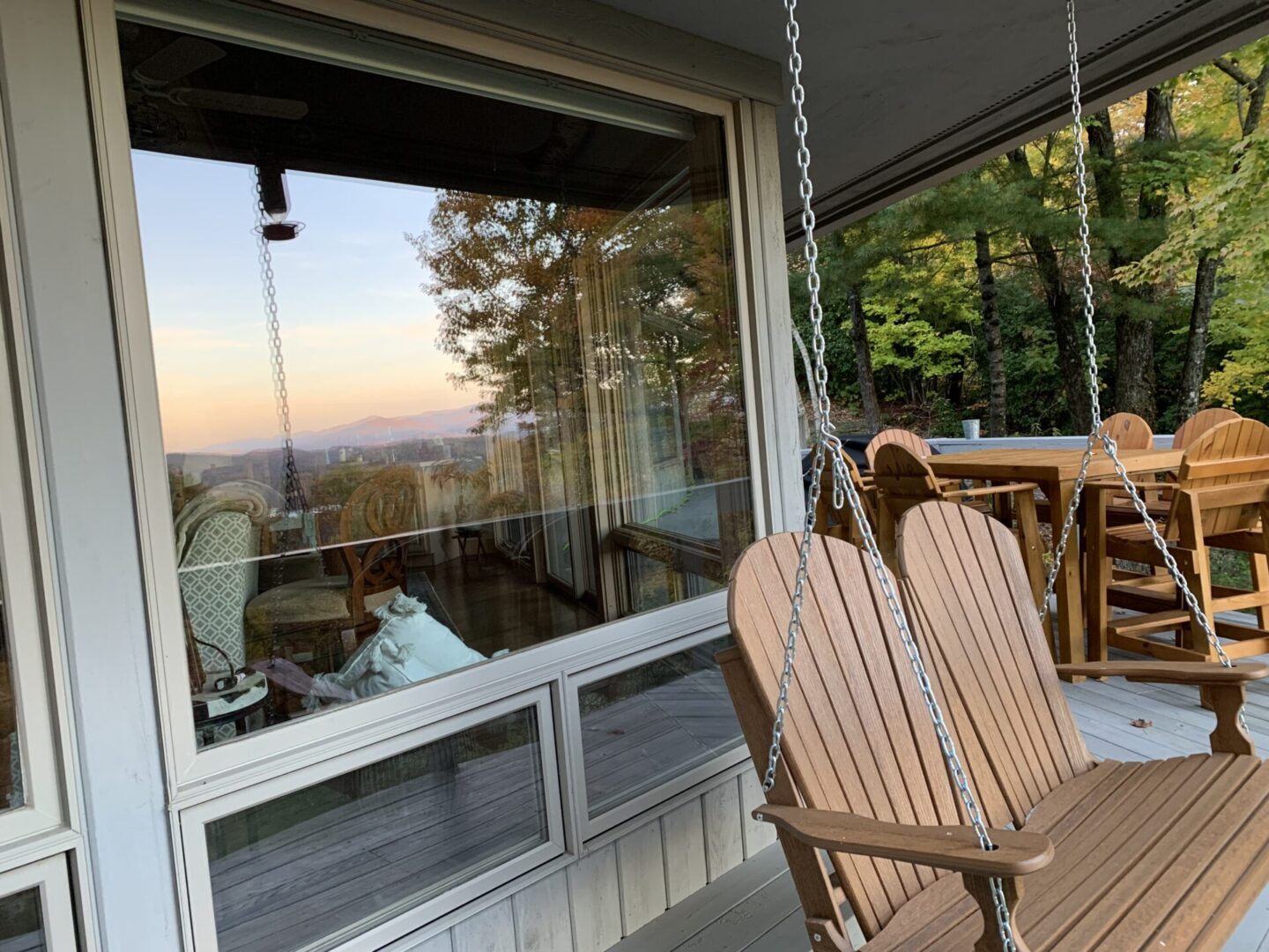 A porch swing with an open view of the mountains.